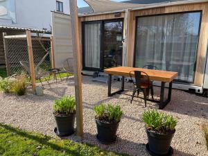 a patio with a wooden table and some plants at Tiny House in Limburg bij Kelly & Nick in Ham