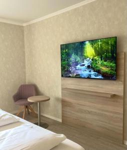 a bedroom with a flat screen tv on a wall at Forsthaus Seebergen in Lütjensee