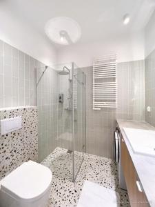 een badkamer met een douche, een toilet en een wastafel bij Vistula Riverside Apartment in Krakau