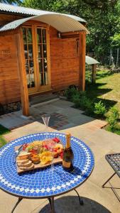 una mesa con un plato de comida y una botella de vino en Sika hut, en Wareham