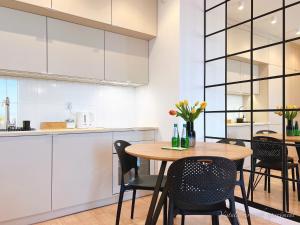 een keuken en eetkamer met een tafel en stoelen bij Vistula Riverside Apartment in Krakau