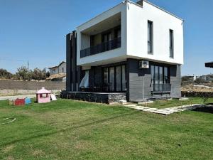 Sakın bir ortamda 3 odalı villa في أنطاليا: منزل أبيض كبير مع ساحة عشبية