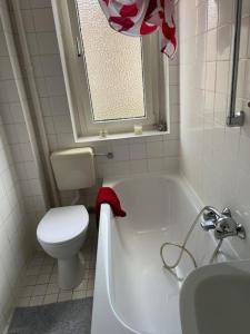 y baño con aseo, bañera y lavamanos. en Room in 3 bedrooms flat, 9 min to MESSE, free parking, en Frankfurt