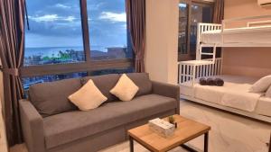 uma sala de estar com um sofá, uma cama e uma janela em B301 Seaview three Beds, two baths At Ao Nang Beach em Praia de Ao Nang