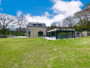 una casa en una colina con un campo verde en Villa Wapiti en Aywaille