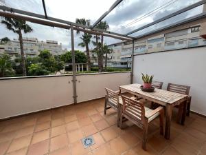 a patio with a wooden table and chairs on a balcony at Altos del Toril 2 habitaciones Wifi y Parking in Torremolinos