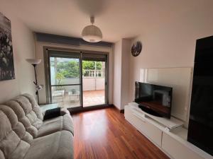 a living room with a couch and a flat screen tv at Altos del Toril 2 habitaciones Wifi y Parking in Torremolinos