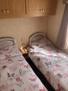 two beds sitting next to each other in a room at Sws Coral Beach in Ingoldmells
