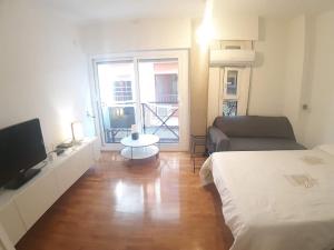 ムルシアにあるAPARTAMENTO PATRICIAのベッド、テレビ、ソファが備わる客室です。