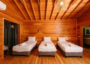 two beds in a room with wooden walls at Pine Valley Hotel Oludeniz in Oludeniz
