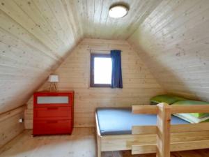 a small room with a bed and a window in a attic at Domki Kaja in Rewal