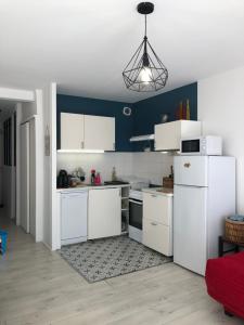 a kitchen with white appliances and a blue wall at KER HEDWIGE in Carnac