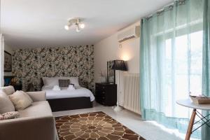 a living room with a bed and a couch at Seafront Villa Nefeli in Keratea +40 photos