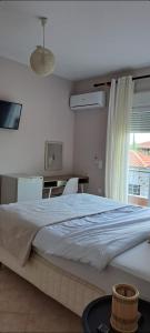 1 dormitorio con cama, escritorio y ventana en FG Home Rental, en Xanthi