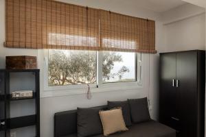 a living room with a couch and a window at Seafront Villa Nefeli in Keratea