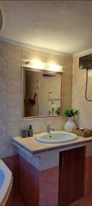 uma casa de banho com um lavatório e um espelho em FG Home Rental em Xanthi