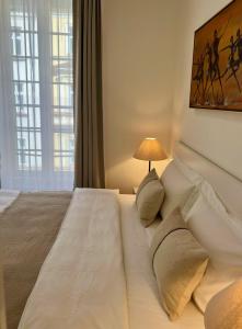 sypialnia z dużym białym łóżkiem z lampką w obiekcie CITY CENTRUM CHARMING apartment w Pradze