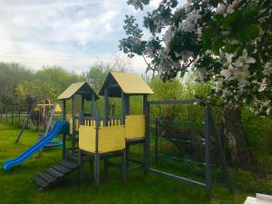- une aire de jeux avec toboggan dans la pelouse dans l'établissement Domki Letniskowe Kaja, à Rewal