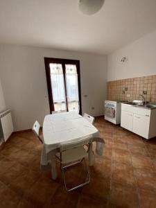eine Küche mit einem weißen Tisch im Zimmer in der Unterkunft Casa Gina in Porto Torres