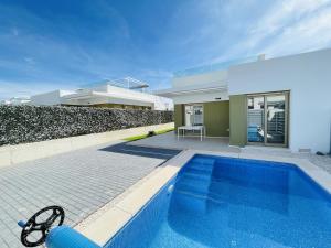 a swimming pool in front of a house at 3084 Res MAUI II in Orihuela