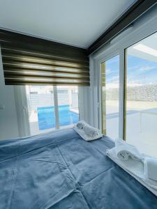 1 dormitorio con cama azul y ventana grande en 3084 Res MAUI II, en Orihuela