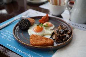 a plate of food with eggs and bread on a table at Mulranny Park Hotel in Mulranny