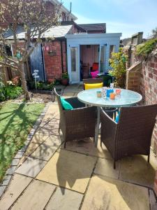 a patio with a table and chairs in a yard at Dune Cottage in Caister-on-Sea