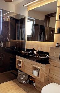 a bathroom with two sinks and a large mirror at Tessa Apartment in Floreşti