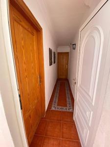 a hallway with a wooden door and a tile floor at Cosy twin beds La Baja in Santa Cruz de Tenerife