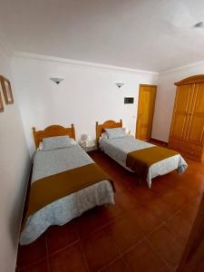 two beds in a room with wooden floors at Cosy twin beds La Baja in Santa Cruz de Tenerife