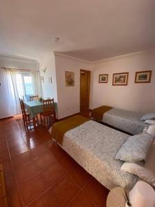 a bedroom with two beds and a table and a dining room at Cosy twin beds La Baja in Santa Cruz de Tenerife