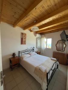 a bedroom with a large bed and a wooden ceiling at Popi's House in Pentati