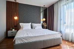 een slaapkamer met een groot bed met witte lakens bij Villa 6 in Podstrana