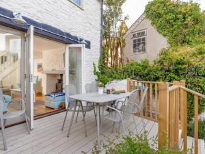 a patio with a table and chairs on a deck at Rose Cottage in Stoke Fleming