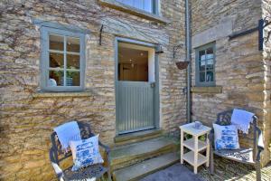 two chairs sitting outside of a house with a door at The Snug at Ruston, Cosy Dog Friendly Cottage in Wykeham