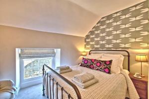 a bedroom with a bed and a window at The Snug at Ruston, Cosy Dog Friendly Cottage in Wykeham