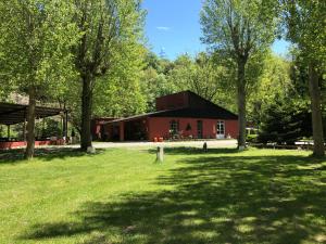 a red barn with trees in front of it at Camping Aigües Braves in Llavorsí