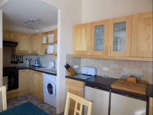 a kitchen with wooden cabinets and a washer and dryer at 5006 Port Brescou 310 in Cap d'Agde