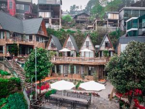 a row of houses with tables and white umbrellas at Tuong Vi Homestay - Venuestay in Vĩnh Phúc