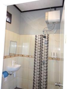 uma casa de banho com um lavatório, um WC e um chuveiro em G-Rima Home Stay em Labuan Bajo