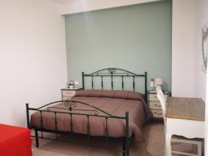 1 dormitorio con cama con colcha rosa y mesa en Da Alduccio, en Vico del Gargano