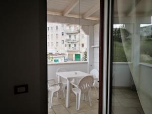 d'une table et de chaises blanches sur un balcon. dans l'établissement Da Alduccio, à Vico del Gargano