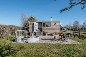 a tiny house with a patio and a table and chairs at Lily Pad in Saxmundham