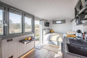 a tiny house with a bedroom and a bed at Lily Pad in Saxmundham