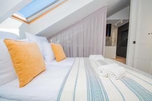 Un dormitorio con una cama blanca con toallas. en InPoint Old Town Apartments, en Cracovia