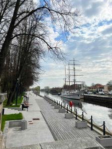 a boat is docked next to a walkway next to a river at Liepu gatve in Klaipėda