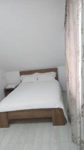 a bedroom with a bed with a white mattress and a curtain at Cazare Paiu VasiVasi in Vaslui