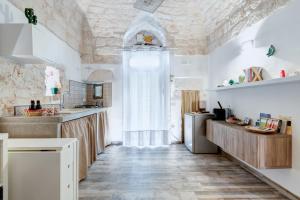 une cuisine avec des murs blancs et un plafond dans l'établissement Casa Anmori, à Ostuni