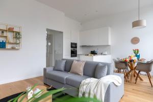 a living room with a gray couch and a kitchen at Sweet Inn - Churchill in Brussels