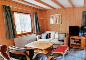 a living room with a couch and a table and a tv at Ferienhaus "Seelöwe Baabe" in Baabe